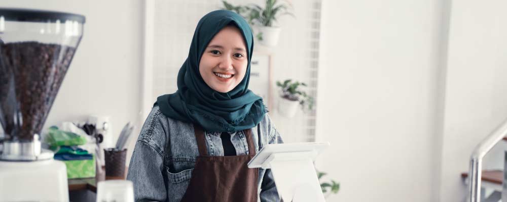 A woman barista at a coffeeshop counter