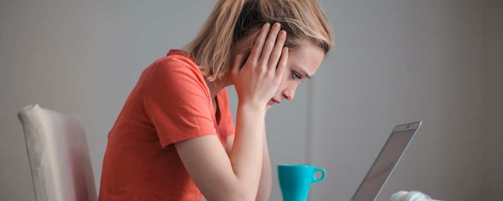 Woman distraught at her computer.