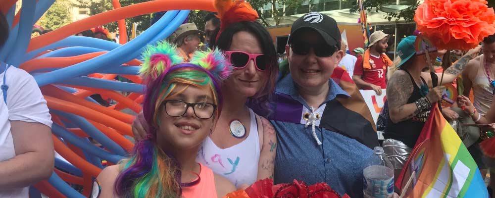 BC NDP supporters in colourful pride parade costumes smile for photos