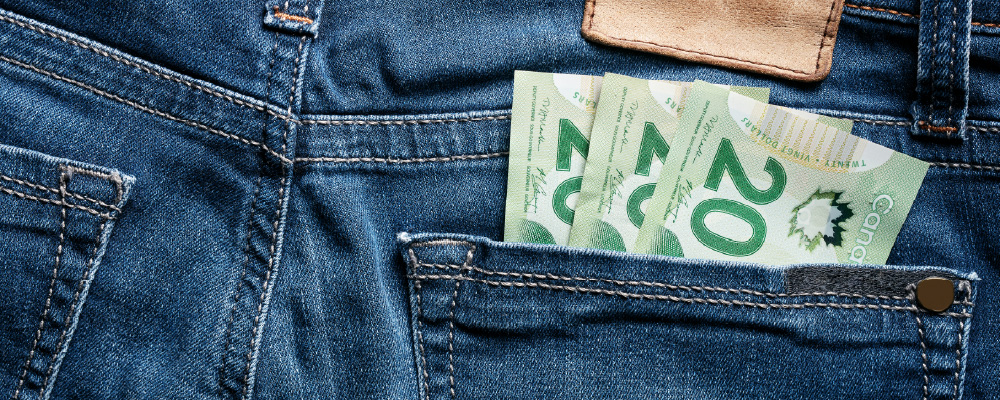 Canadian $20 bills in the back pocket of a pair of denim jeans.