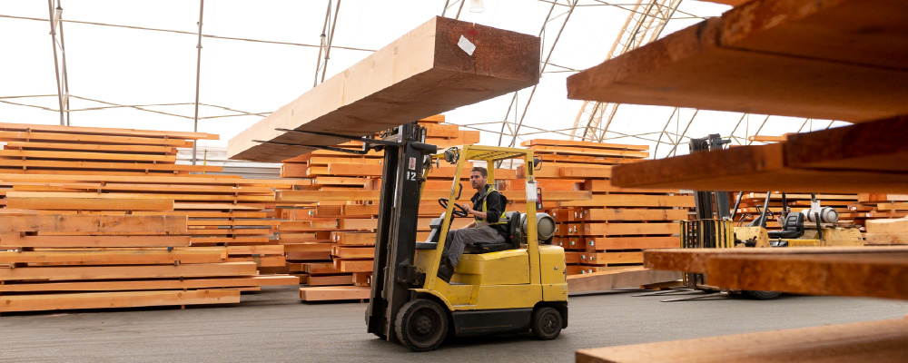 A forklift moves a piece of engineered wood in a BC warehouse